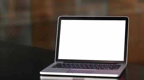 An open mock up laptop computer with blank white screen on black wooden table Stock Photos