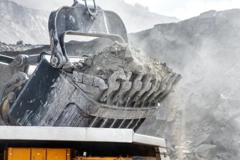 Open mountain quarry. Loading coal into a mining truck. Stock Photos