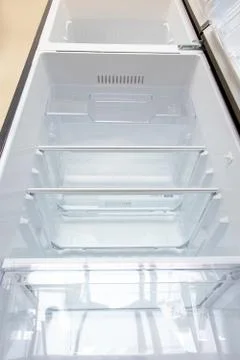 Open new fridge. Empty refrigerator with open door, view from below. Foto stock