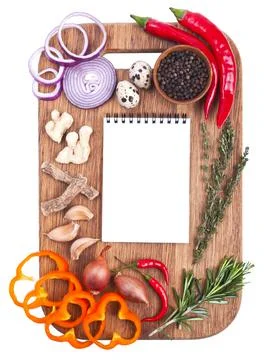 Open notebook and fresh vegetables on an old wooden cutting board. Stock Photos