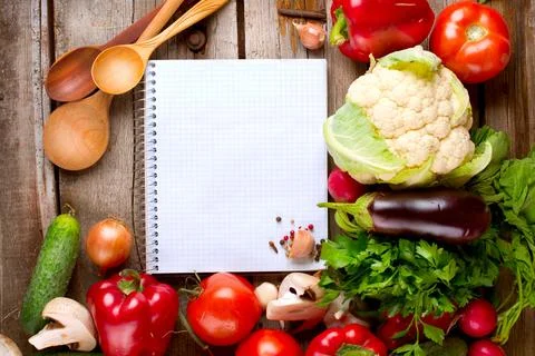 Open Notebook and Fresh Vegetables Background. Diet Stock Photos