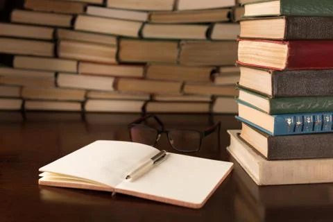 Open notebook and glasses on the background of books Stock Photos