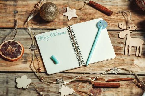 Open notebook and pen on table with christmas gifts and decorati Stock Photos