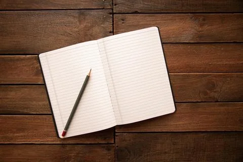 Open notebook and pencil on a rustic wooden board Stock Photos