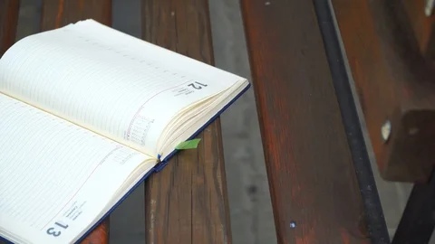 Open Notebook on bench in park, business concept Stock Footage 93342435