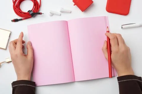 Open notebook with blank pink pages and two hands, concept of writing a plan, Stock Photos