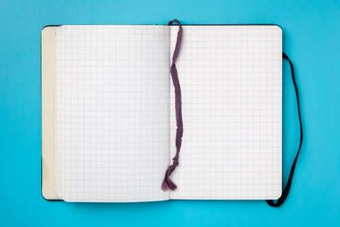 Open notebook on blue background. Stock Photos