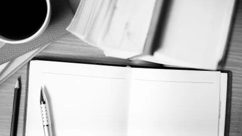 Open notebook with book and coffee cup  black and white color tone style Stock Photos