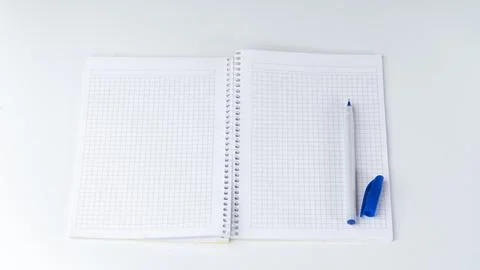 Open notebook in a cage, on the right side there is a pen with an open cap Stock Photos