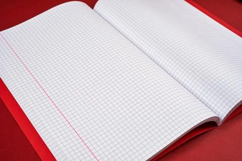 Open notebook with checkered pages on a red background Stock Photos