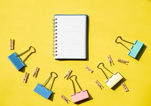 Open Notebook with Clips and Fasteners on Yellow Background Stock Photos