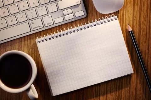 Open notebook with coffee alongside a keyboard Stock Photos