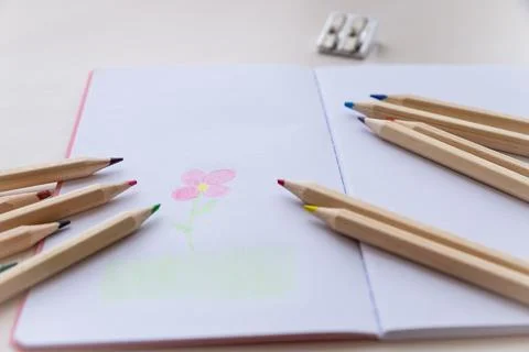 Open notebook, with colored crayons and drawing Stock Photos