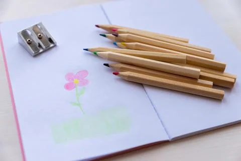 Open notebook, with colored crayons and drawing Stock Photos