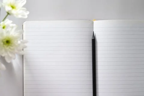 Open notebook, empty pages with cup of coffee, table top. Spring flowers. Stock Photos