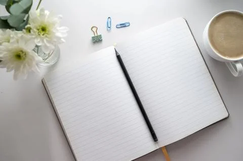 Open notebook, empty pages with cup of coffee, table top. Spring flowers. Stock Photos