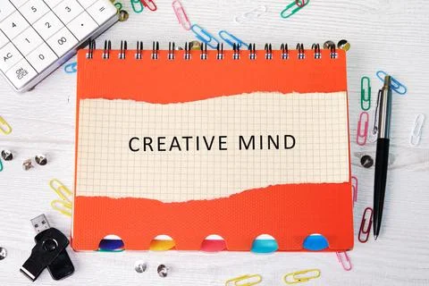 An open notebook featuring Creative mind text on a grid page rests on a desk Stock Photos
