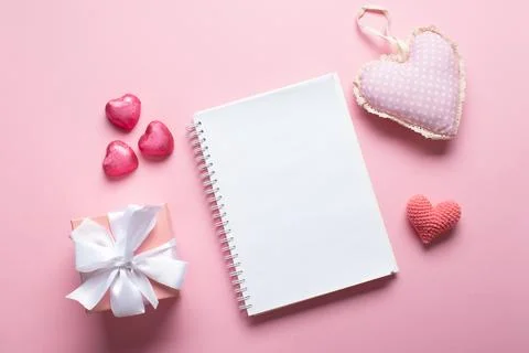 An open notebook with a gift and sweets on a light pink background. Valentine Stock Photos