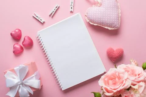 An open notebook with a gift and sweets on a light pink background. Valentine Stock Photos