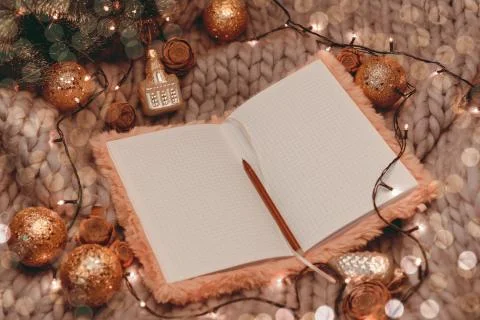Open notebook on gray knitted background with christmas decorations Stock Photos