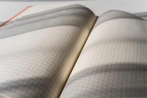 Open Notebook with Grid Pages and Soft Shadows from Natural Light Stock Photos