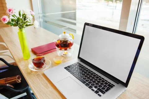 Open notebook, hot tea, table-book and vase with roses stands on table Foto stock