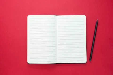 Open notebook isolated on red background, copy space for text. Foto stock