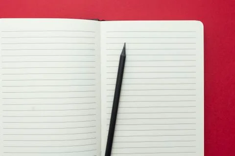 Open notebook isolated on red background, copy space for text. Stock Photos