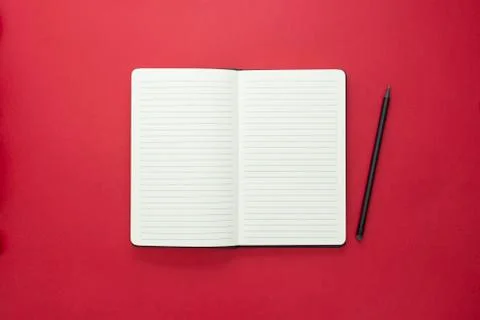 Open notebook isolated on red background, copy space for text. Stock Photos