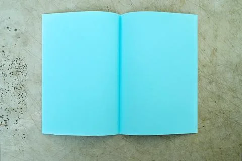 An open notebook with light blue blank pages lies flat on a weathered, scra.. Stock Photos