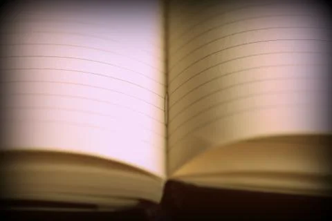 Open notebook with lined pages on a dark background. Retro style toned Foto stock