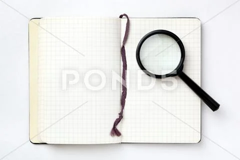 Open notebook with magnifying glass on white background. search concept. Stock Photos