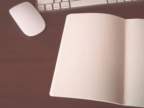 Open notebook with mouse and part of keyboard in vintage tone Stock Photos