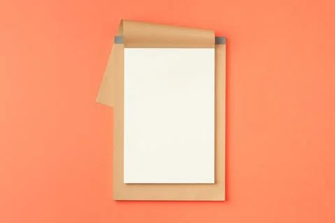 Open notebook on orange background. Stock Photos