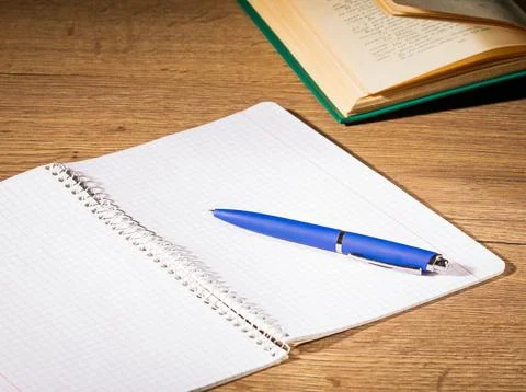 An open notebook with a pen lying on it prepared for writing on the office table Stock Photos