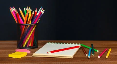 Open notebook with pencils in jar in a concept of primary education, design,  Stock Photos