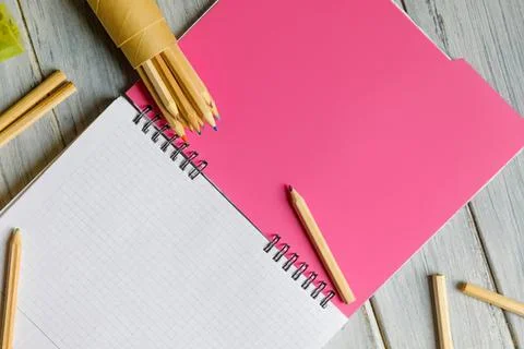 Open notebook with pink and white pages on wooden table Stock Photos