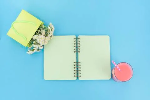 Open notebook for records lies on the surface of the cocktail pink glass tube Stock Photos