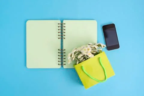 Open notebook for records lies on the surface of the cocktail pink glass tube Stock Photos