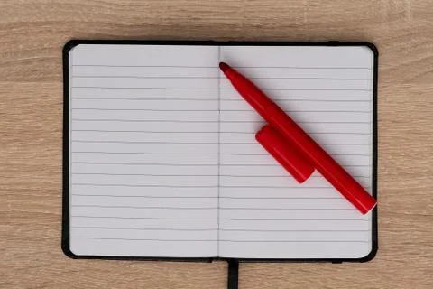Open notebook with red pen on desk Foto stock