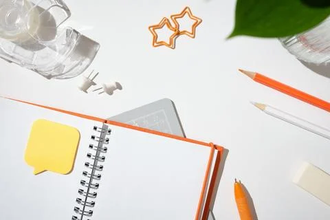 Open notebook with a speech bubble sticky note, orange pen, and star-shaped.. Stock-Fotos