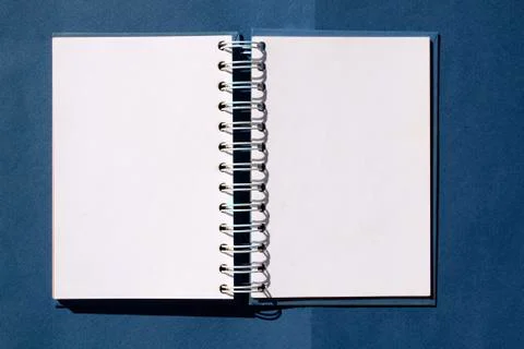 Open notebook on a spring on a blue background. Mockup. space for text Stock Photos