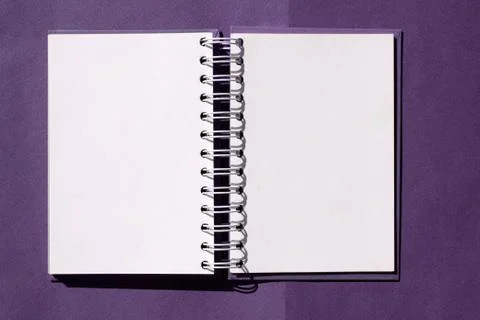 Open notebook on a spring on a purple background. Mockup. space for text Foto stock