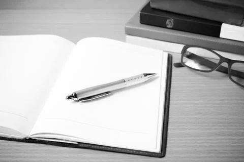 Open notebook with stack of book black and white color tone styl Stock Photos
