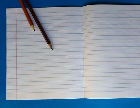 Open notebook on a white lining on a blue wooden tabletop with a pencil Fotos Stock