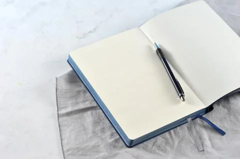 Open notebook on white marble background Stock Photos