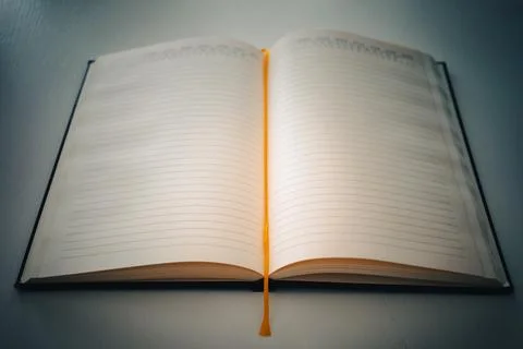 An open notebook on a white table 스톡 사진