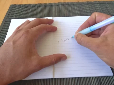 Open notebook, writing handwritten phrases of love and positivity Stock Footage 321018315