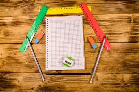 Open notepad and different stationeries on a wooden table. Top view Stock Photos