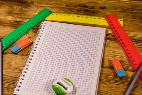 Open notepad and different stationeries on a wooden table Stock Photos